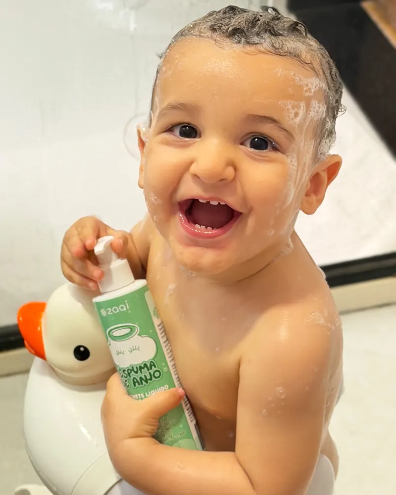Beb&ecirc; rindo na banheira segurando a Espuma de Anjo