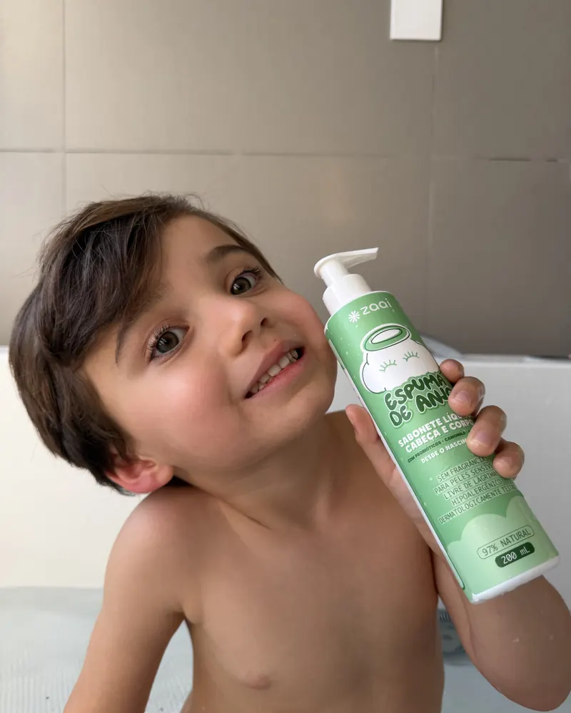 Menino na banheira com o frasco da Espuma de Anjo