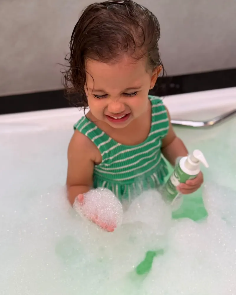 Menina sorrindo no banho de espuma